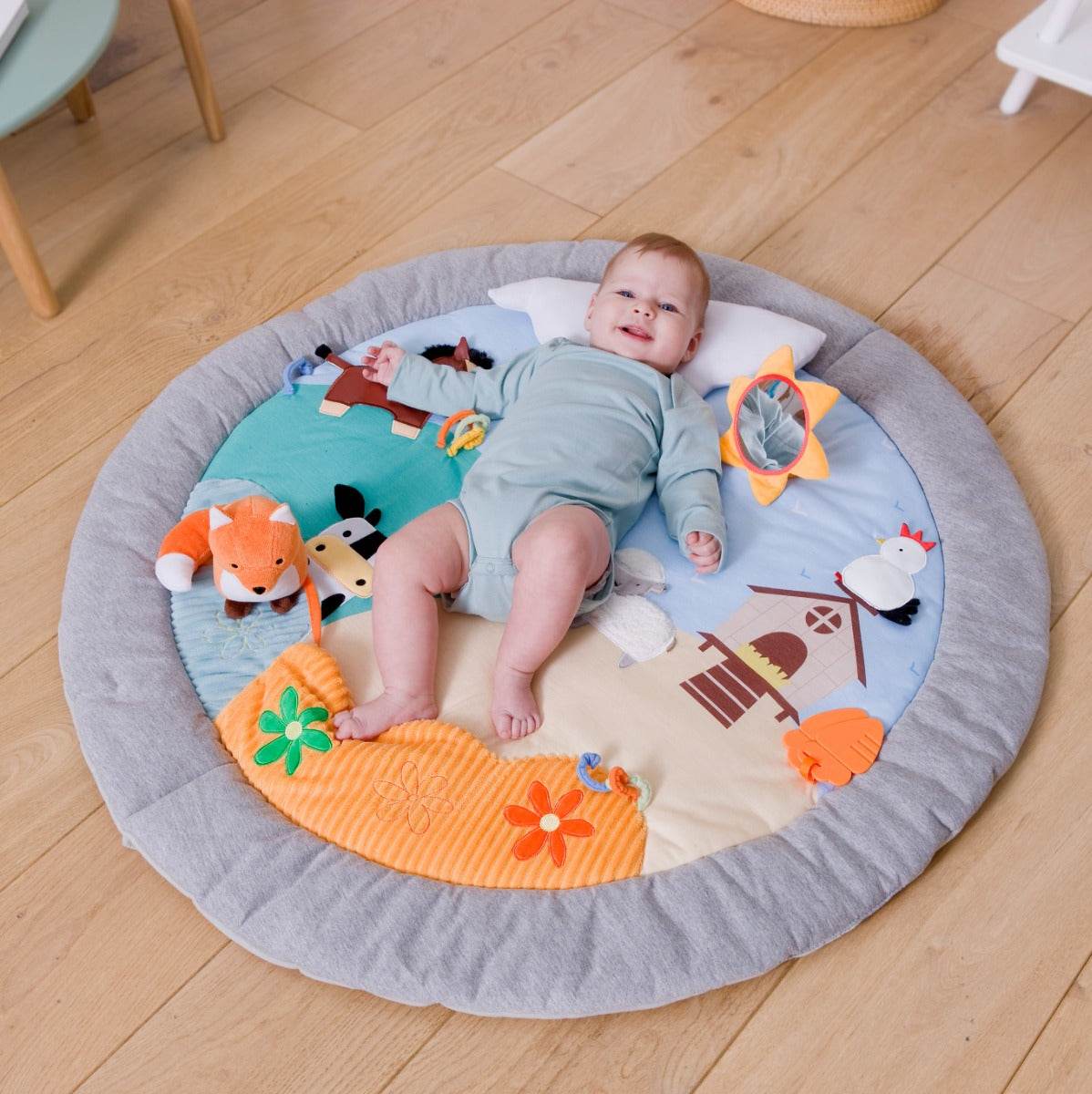 Baby lying on Little Big Friends Activity Playmat farm theme