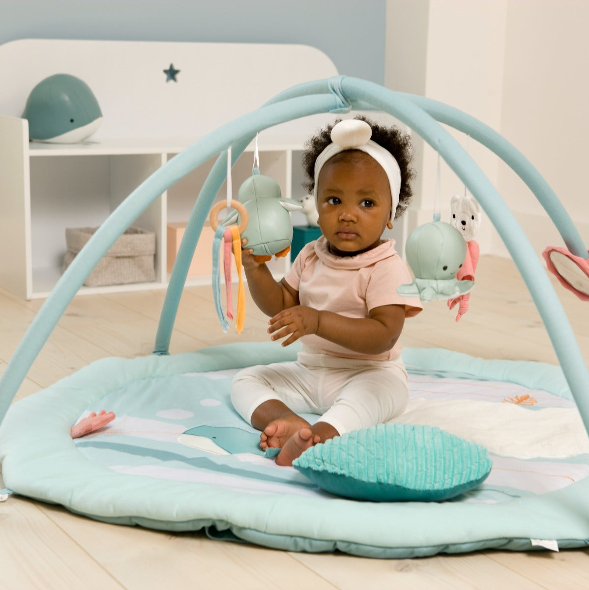 Baby sitting on Little Big Friends Activity Mat with Arch in ocean