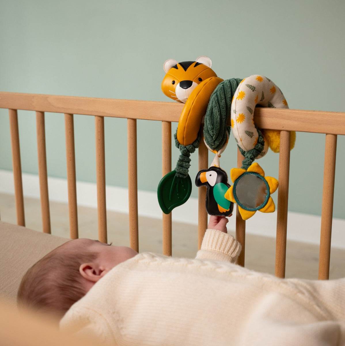 Baby playing in cot with Tiger head jungle theme activity spiral for kids from little big friends