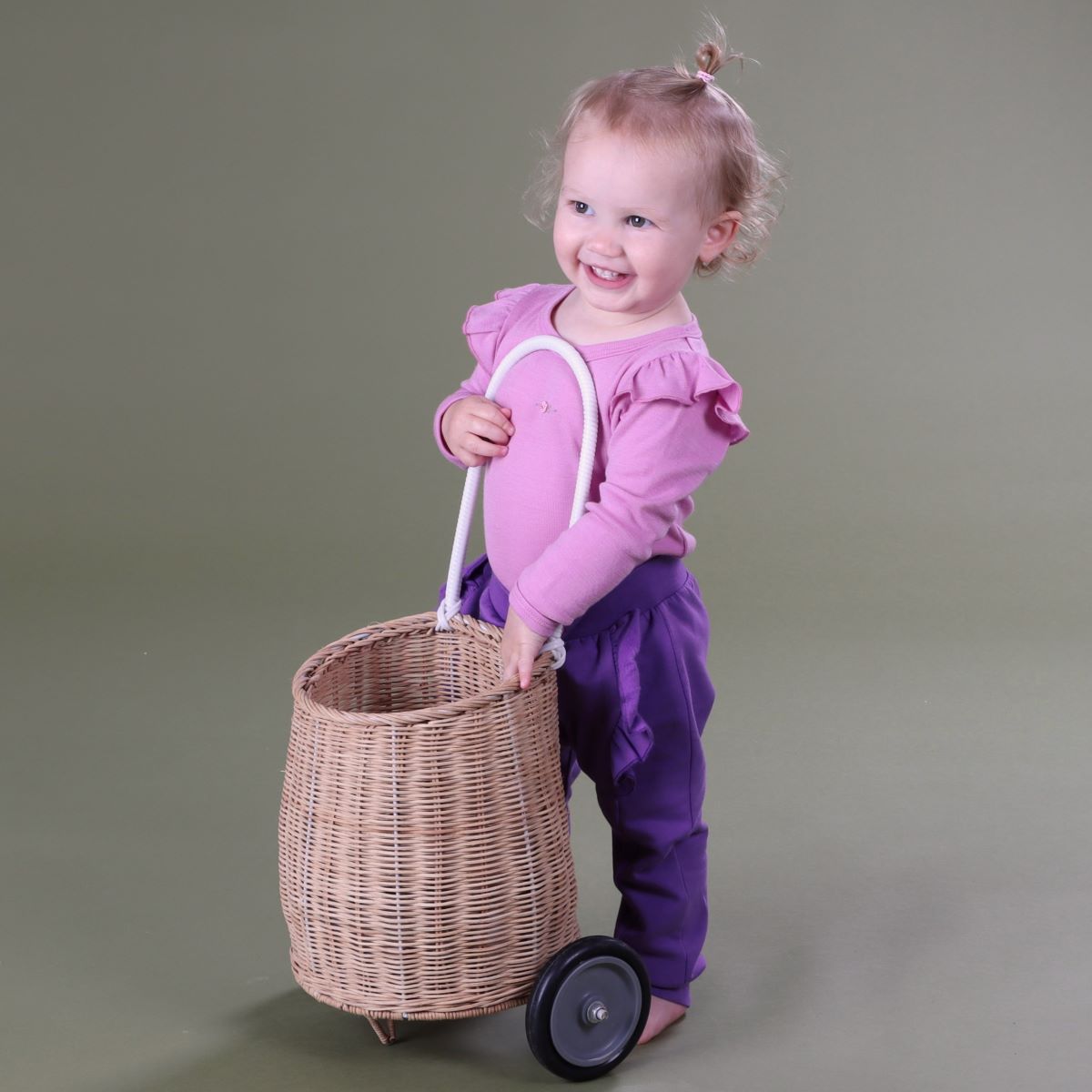 Baby wearing Orchid Merino frill bodysuit pairing it with purple pant