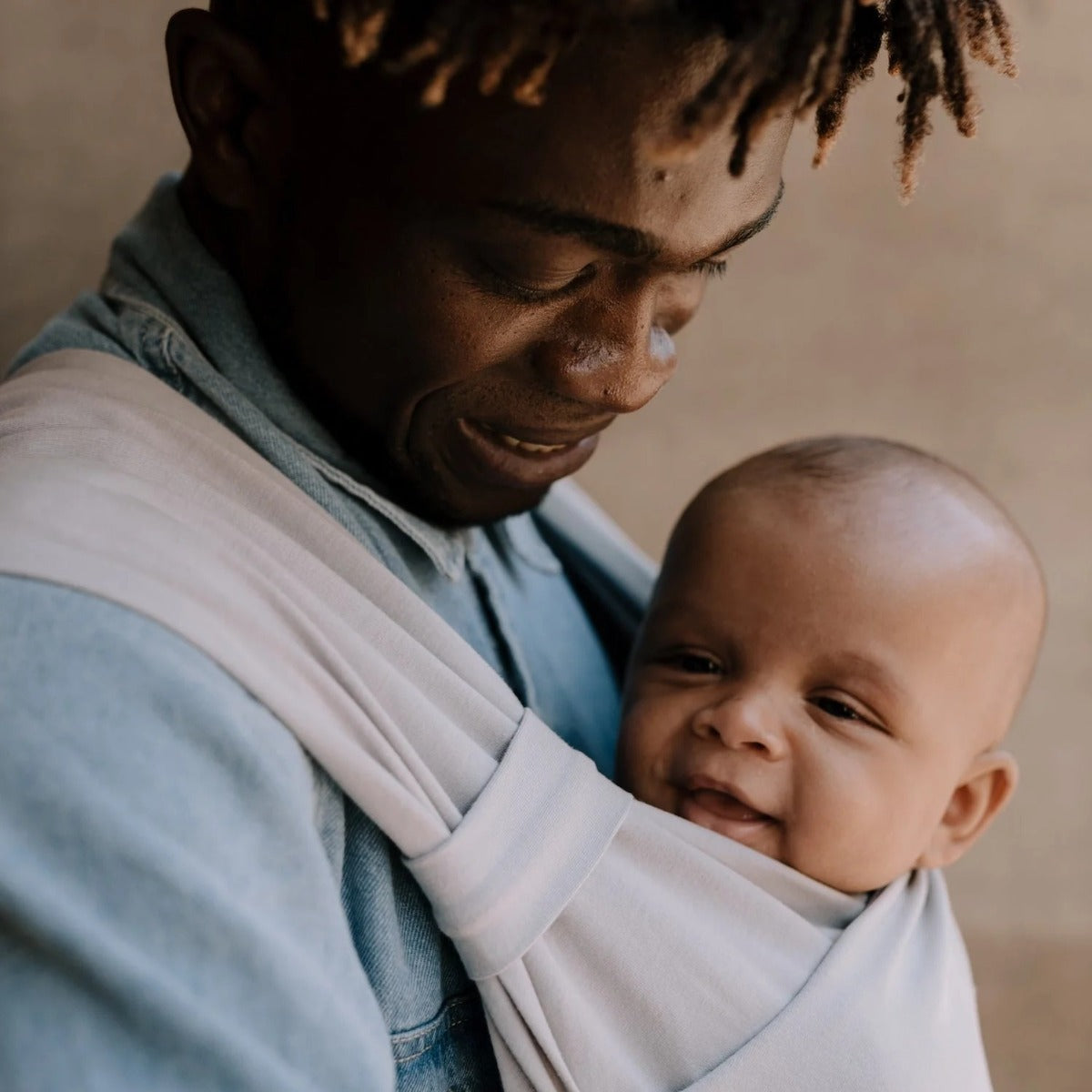 Man holding baby in Boba Bliss carrier in grey Close up