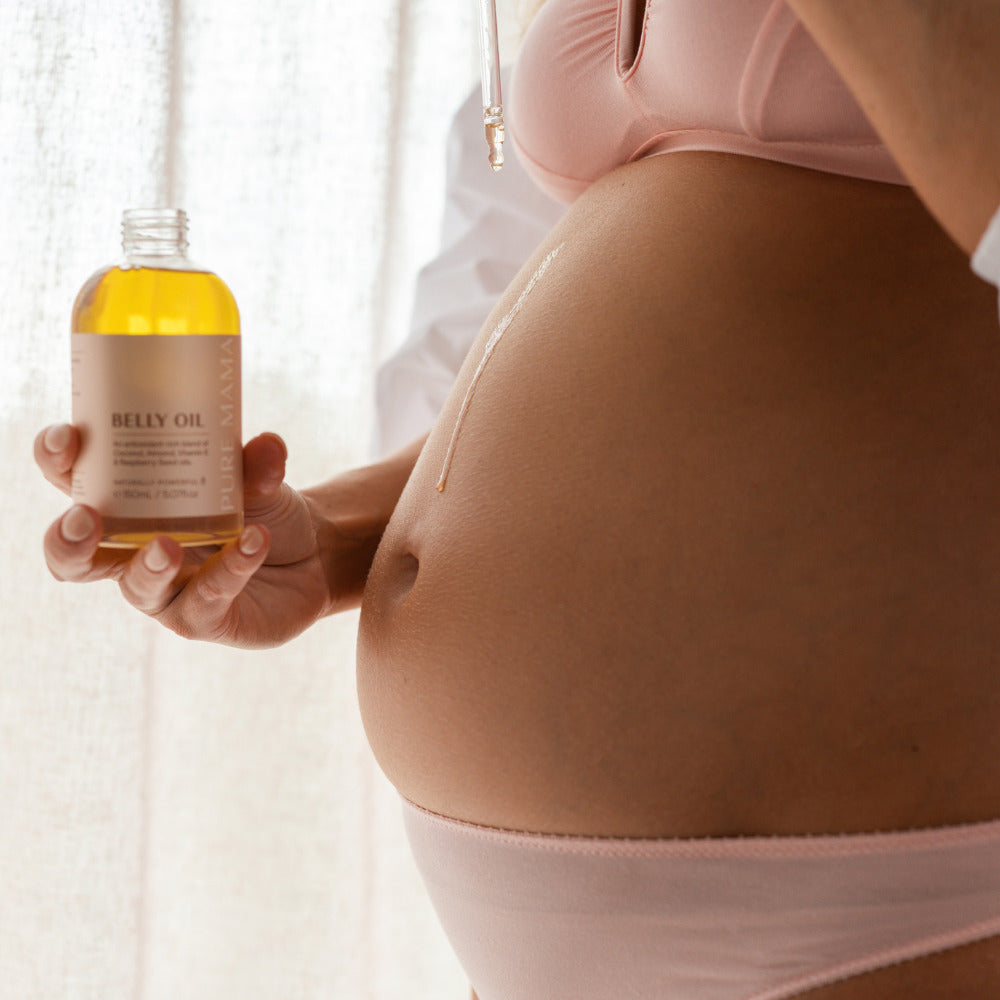 Pure Mama Belly oil being used on pregnant belly