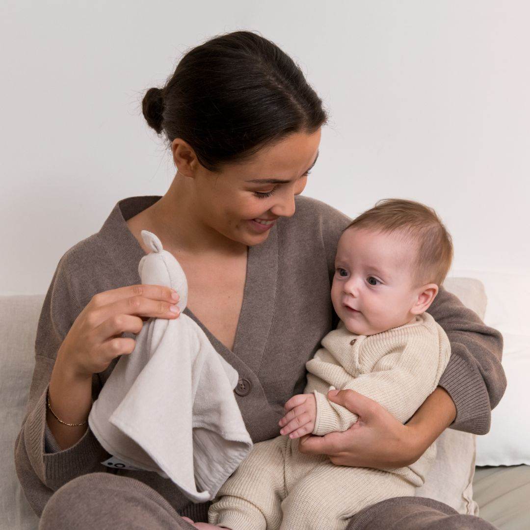 Mother and baby playing with doomoo bunny detachable baby soother in almond