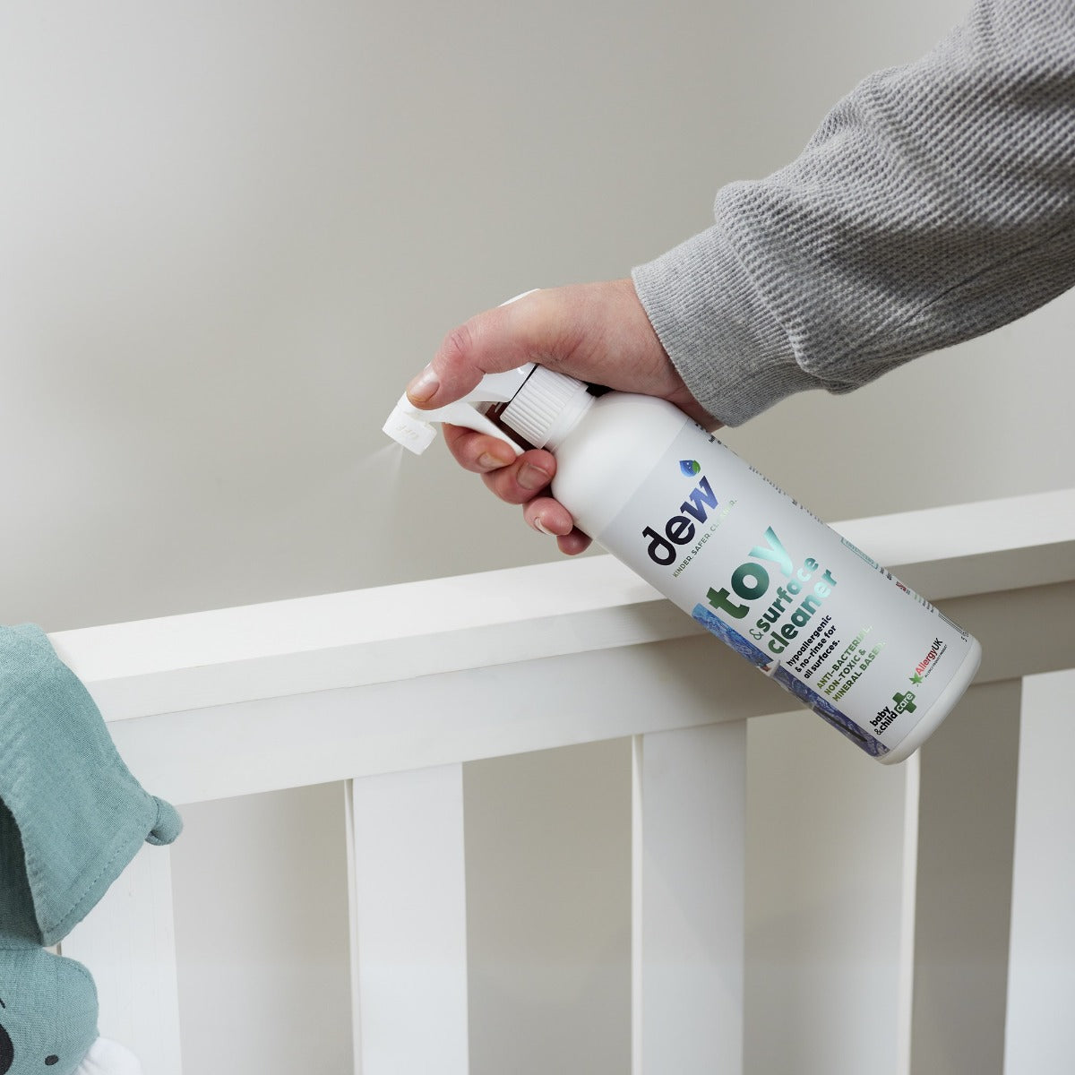 Mother cleaning cot with Toy & Surface Sanitizer