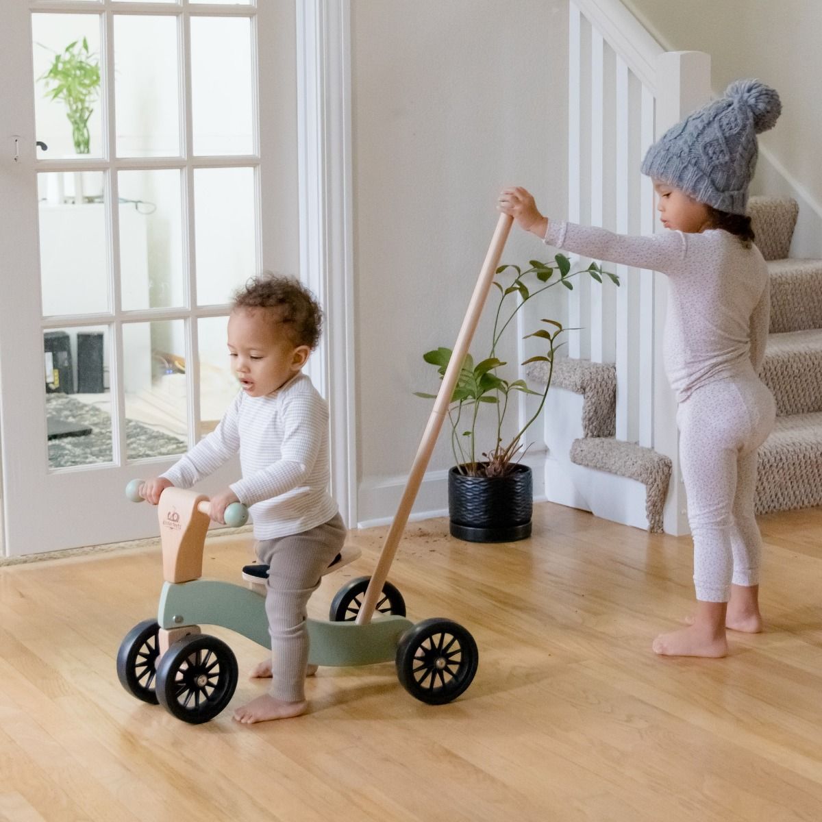Two Children Playing With Kinderfeets Tiny Glider With Pole