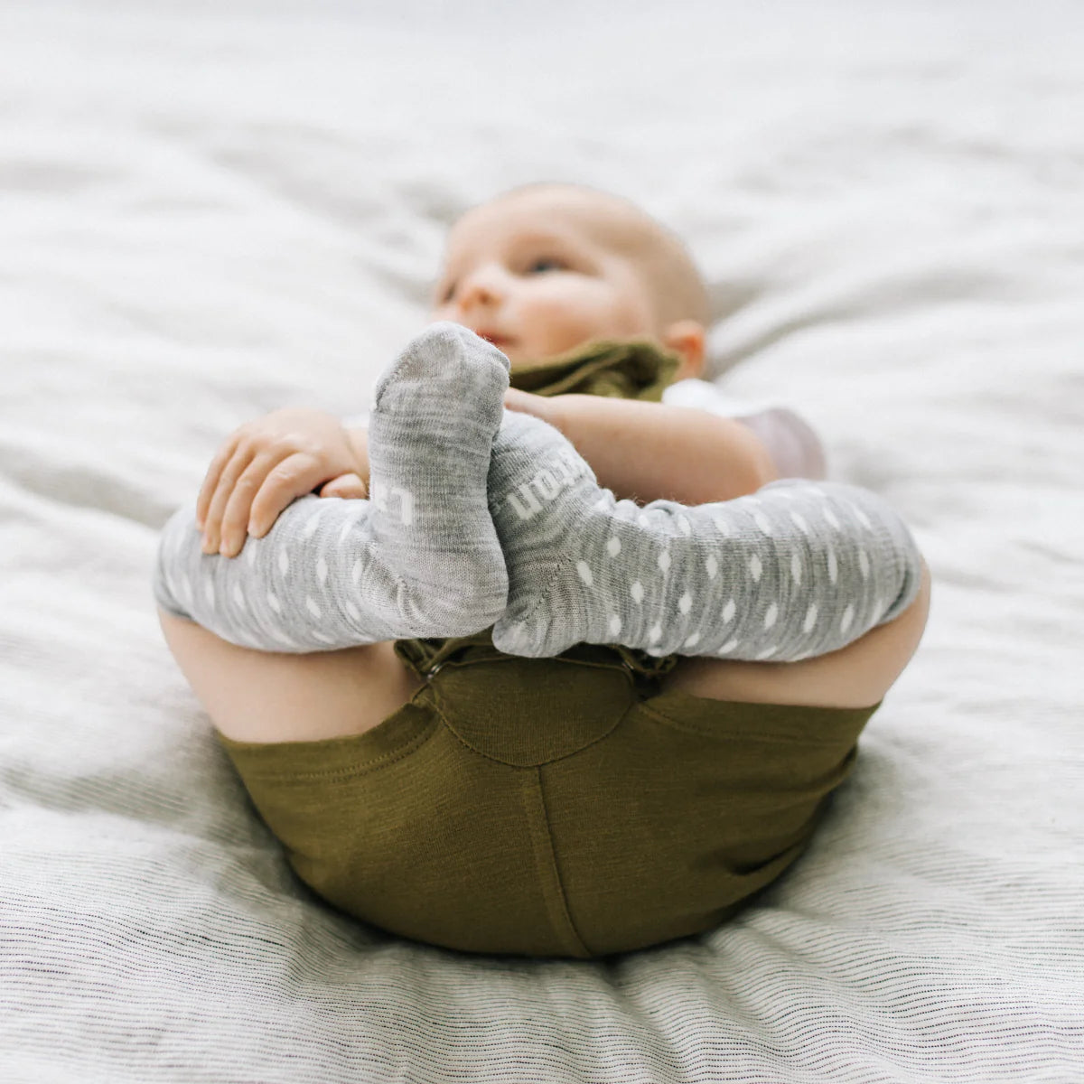 Baby wearing Merino Wool Kneehigh Socks for baby from Lamington in grey and white