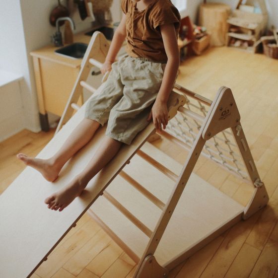 Child sliding on Kinderfeets Pikler Ramp/Slide