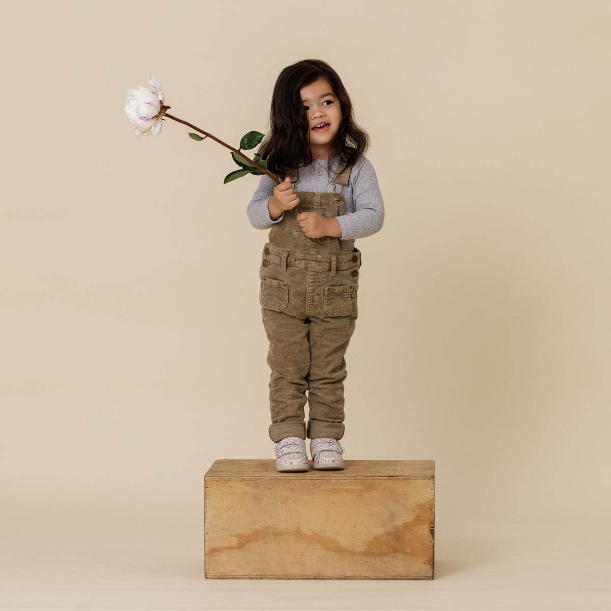 Girl standing on wood block wearing Floral print 1st walker shoes