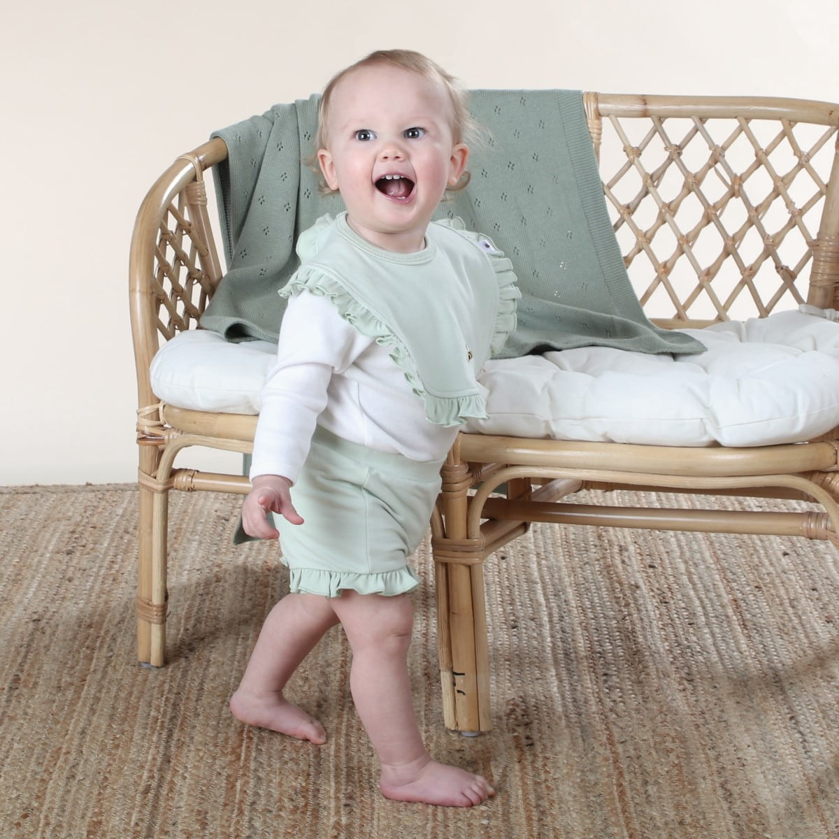 cotton frill bib in sage dimples lifestyle shot