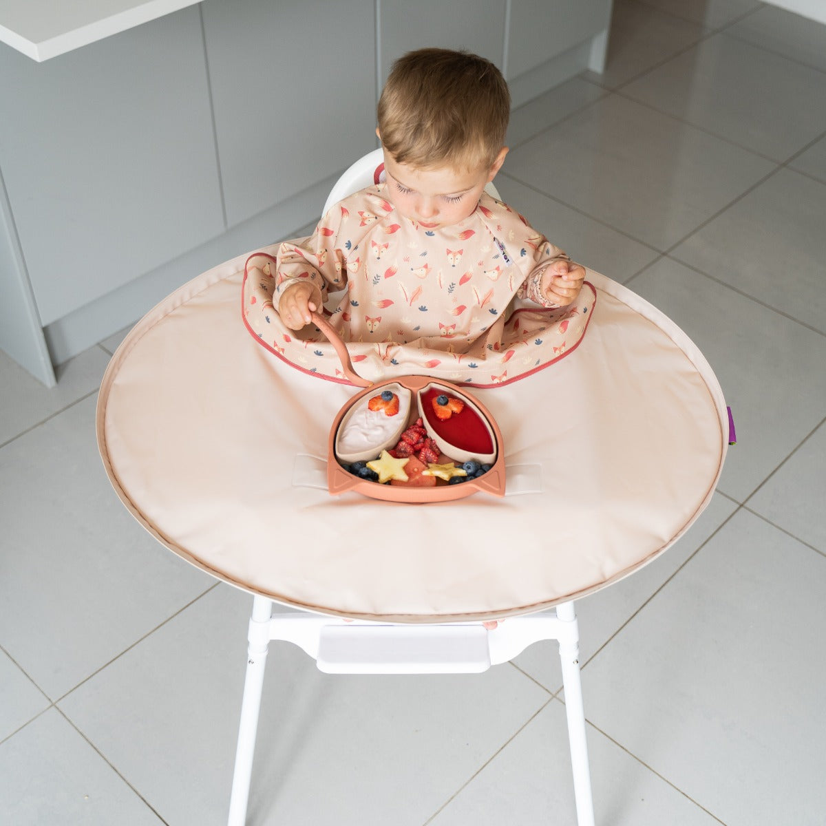 Baby eating with Tidy Tot tray around highchair and long sleeve fox bib