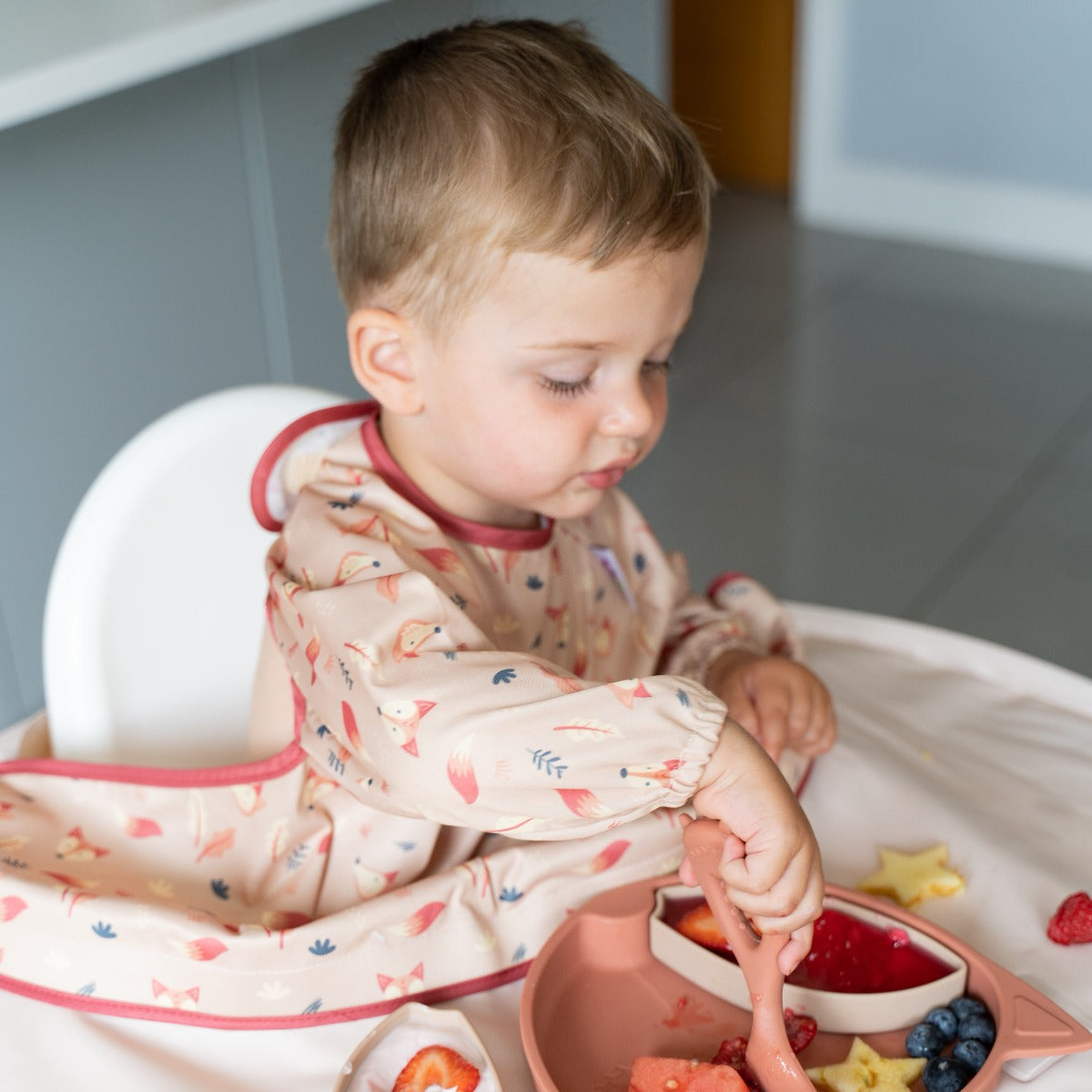 Baby eating wearing overall long sleeve bib with fox print