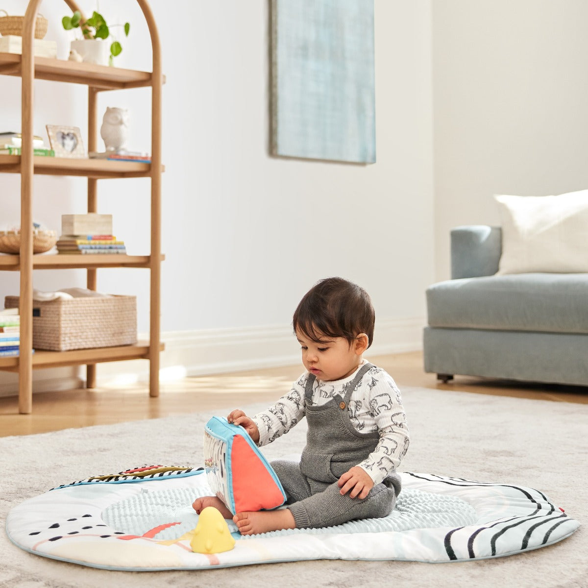Baby boy playing with pillow on a Deluxe Activity Gym - Discoverosity Montessorifrom Skip Hop