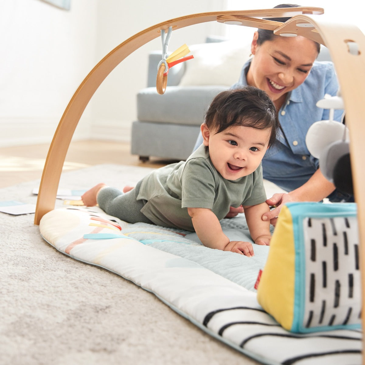Baby boy looking at a toy from Deluxe Activity Gym - Discoverosity Montessorifrom Skip Hop