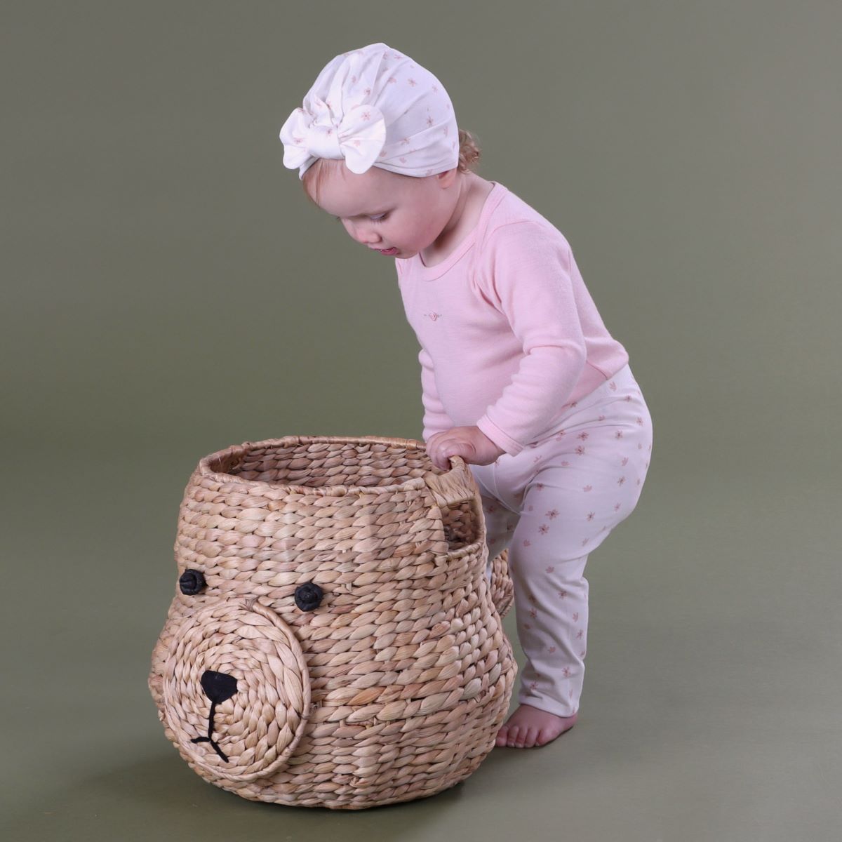Baby girl wearing dainty floral cotton legging with merino long sleeve top and cotton beanie playing with a basket