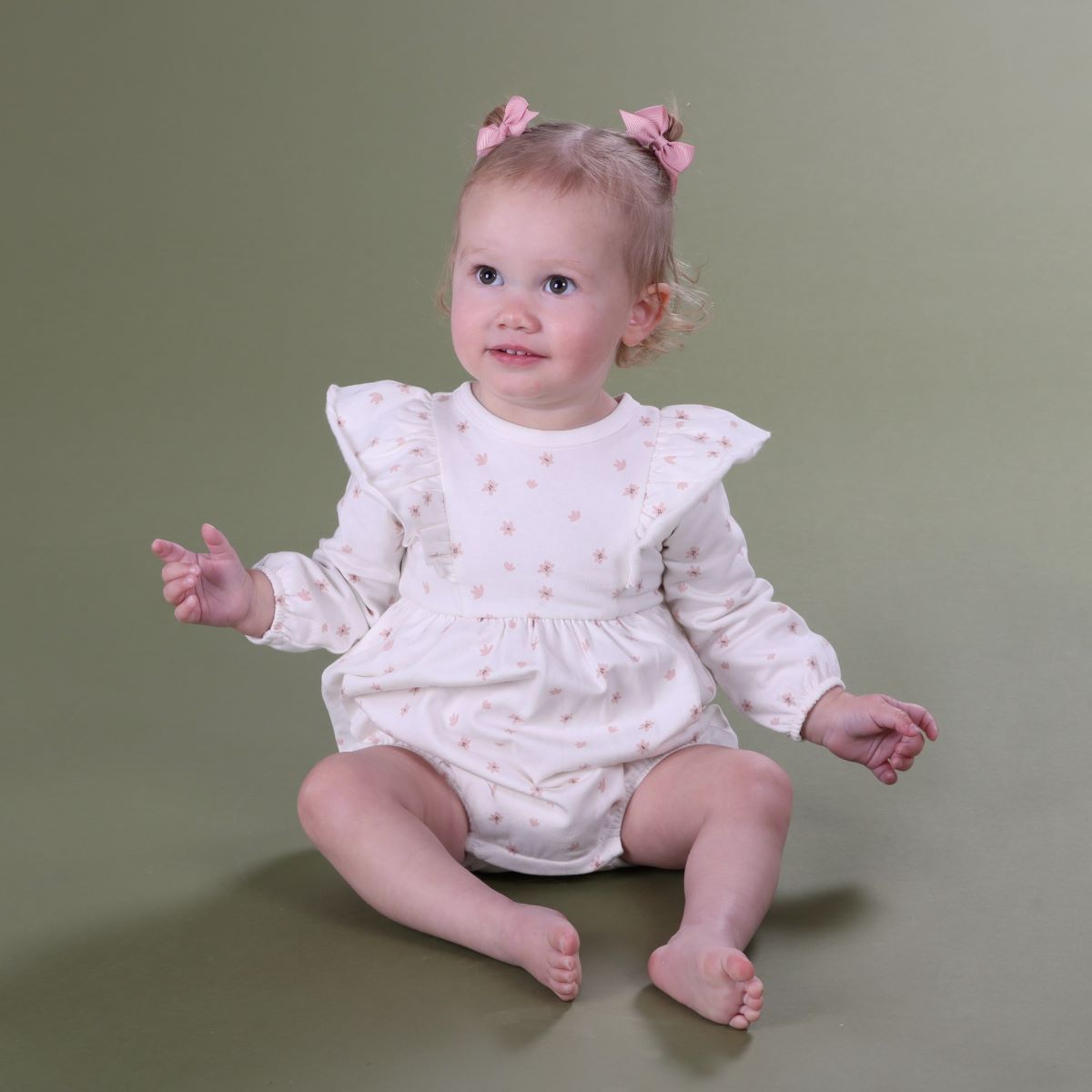 Baby girl playing sitting wearing cotton fleece frill baby romper with floral print