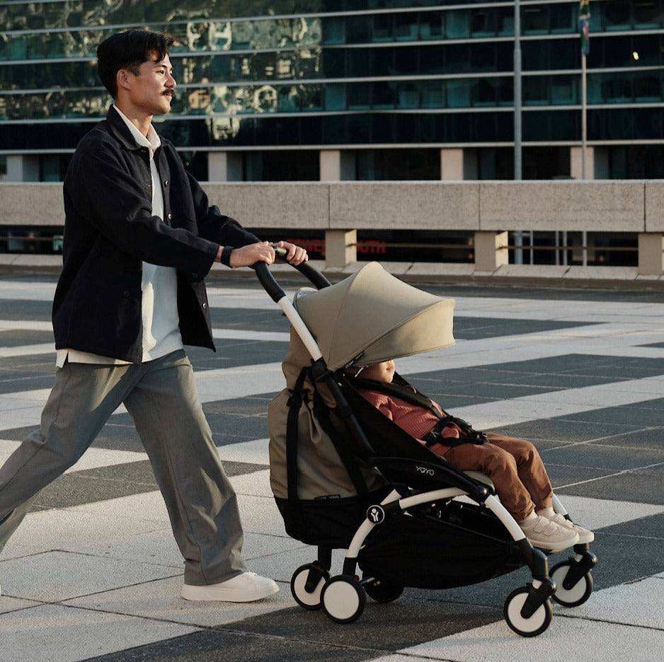 Father walking on street with baby sitting in YOYO3 with 6+ colour pack