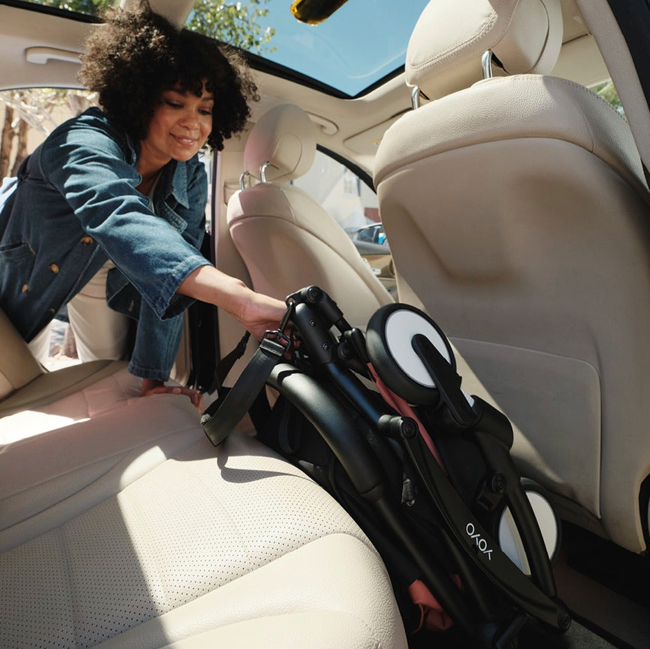 Mother packing and placing pram in car