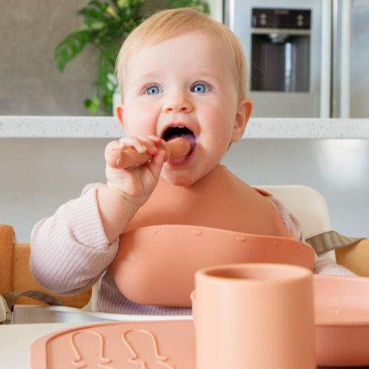 Baby boy eating with silicone bpa-free spoon