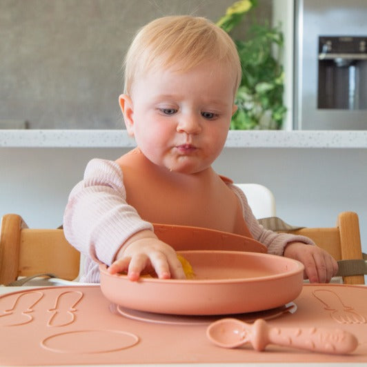 Baby eating from Zazi silicone baby plate with lid