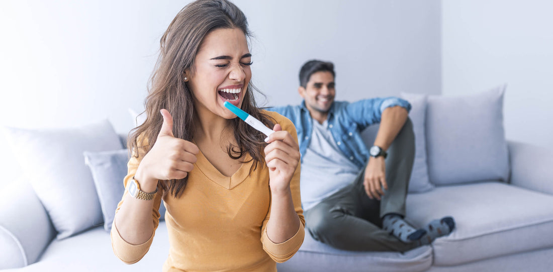 Happy lady holding positive test result of pregancy besides the father to be