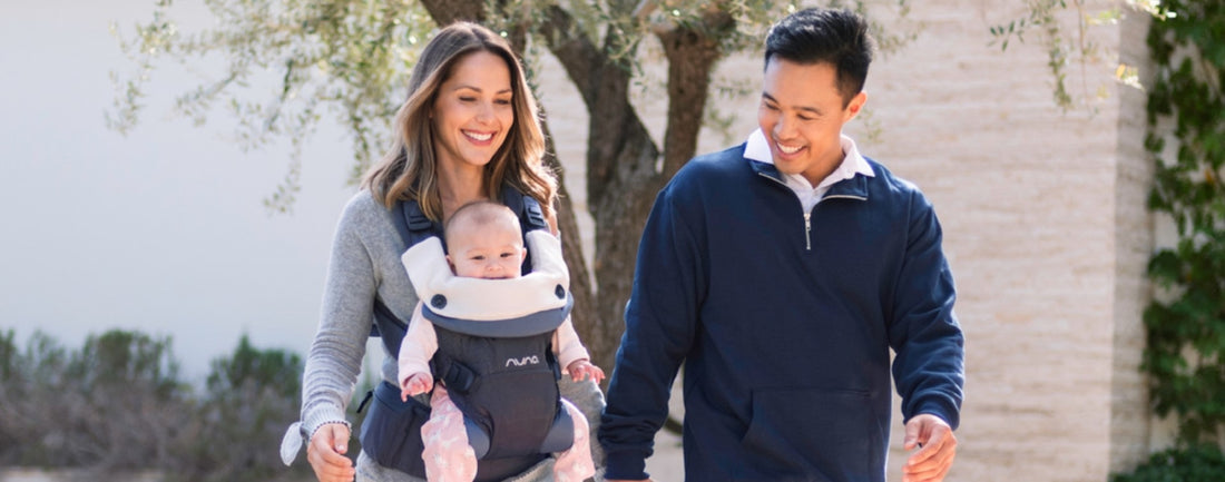 Parents walking, mother carrying baby in Nuna Cudl 