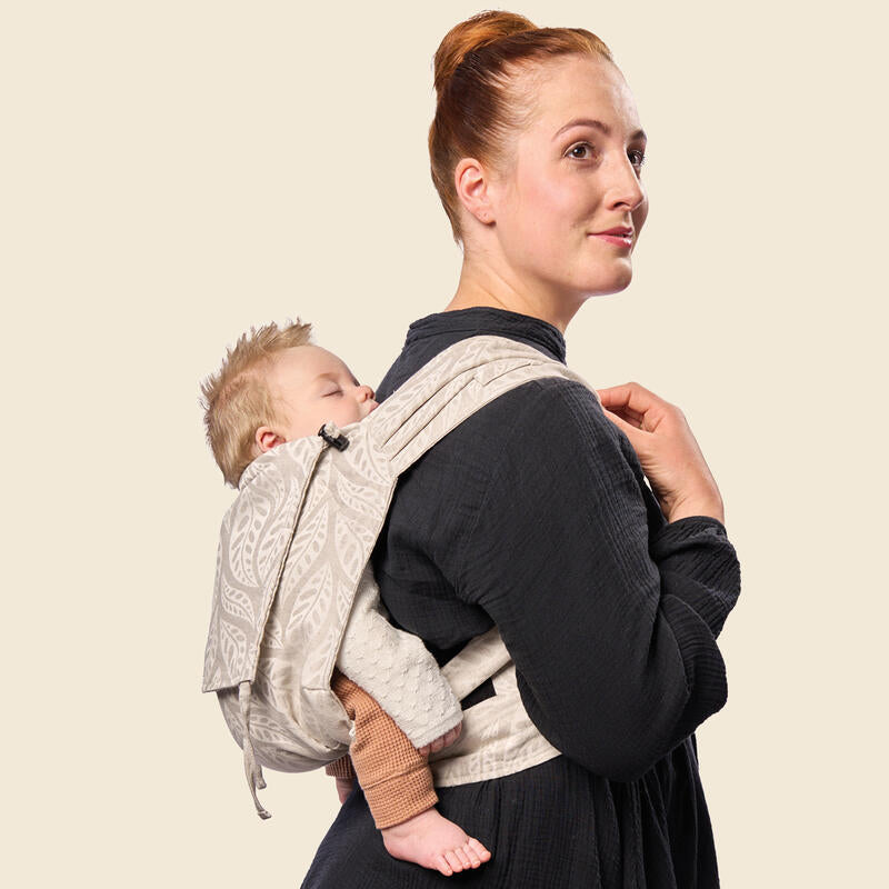 Mother carrying baby in Stokke Limas Carrier plus in valerian beige Back carrying.