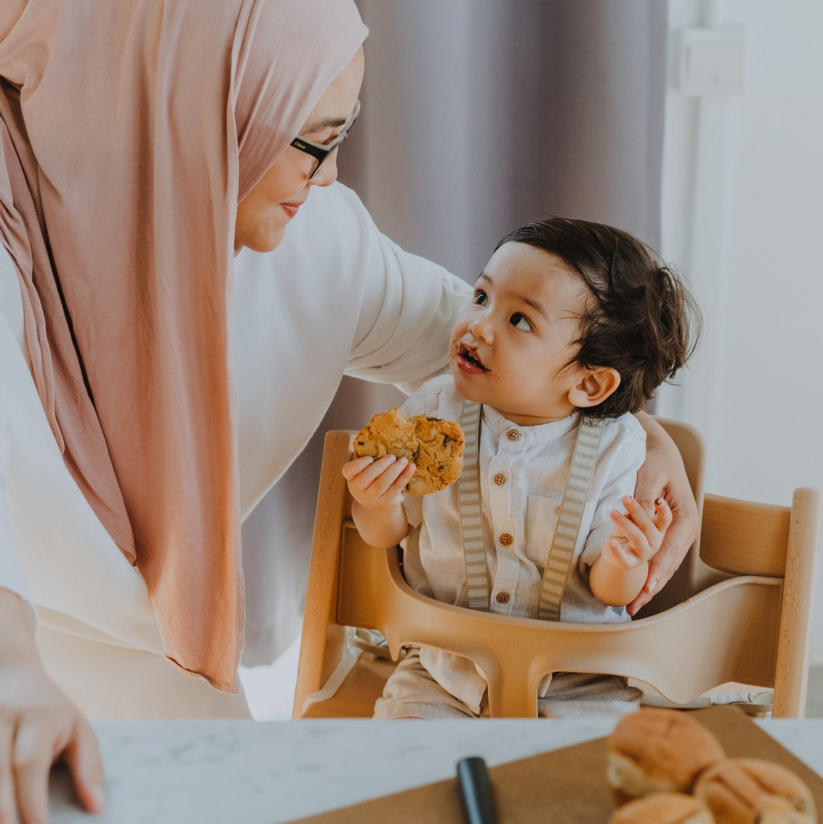 Stokke tripp trapp harness for tripp trapp highchair lifestyle shot with feeding baby and mother