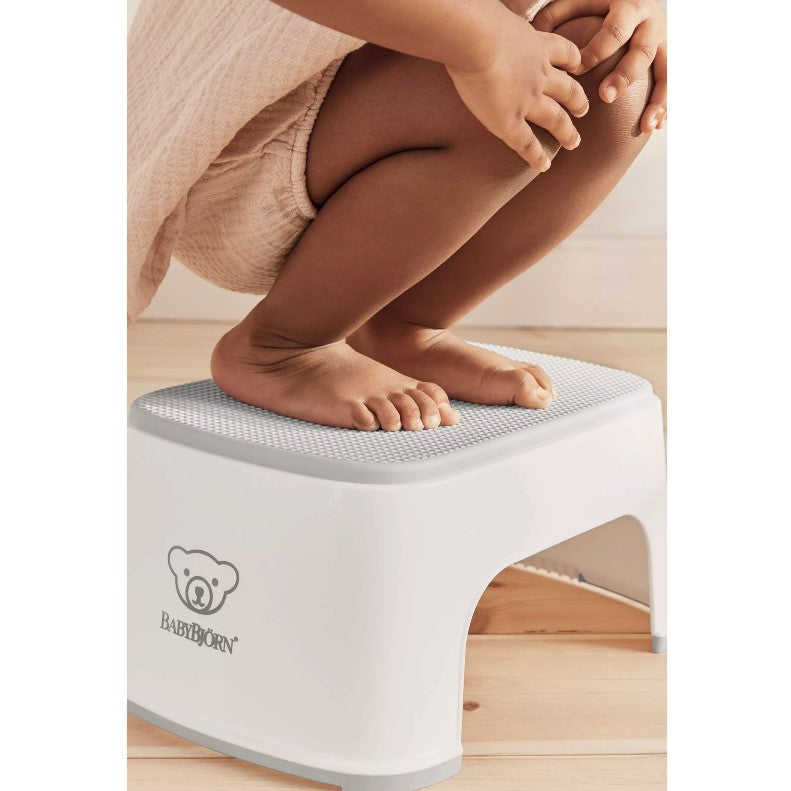baby sitting on Babybjorn White Step Stool