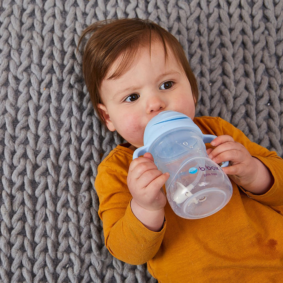 Baby boy sleeping and drinking water from B.Box Bubble gum sippy cup