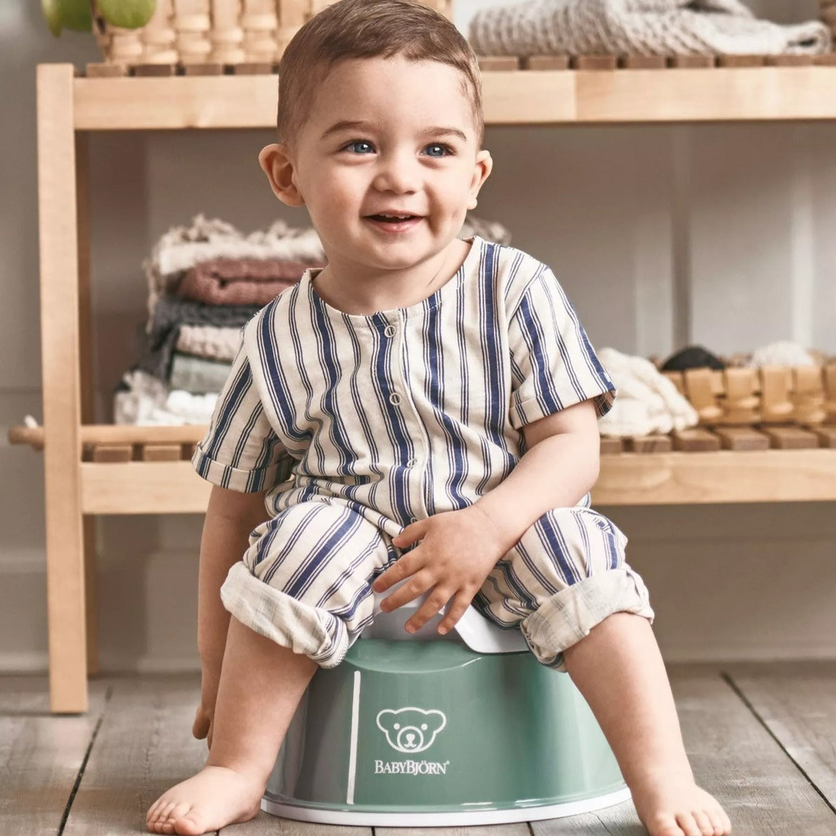 Baby boy sitting on Babybjorn Smart Potty in green