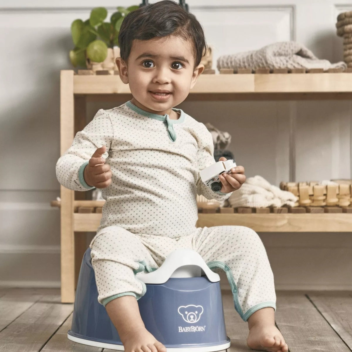 Baby boy sitting on a Babybjorn Blue Smart Potty seat