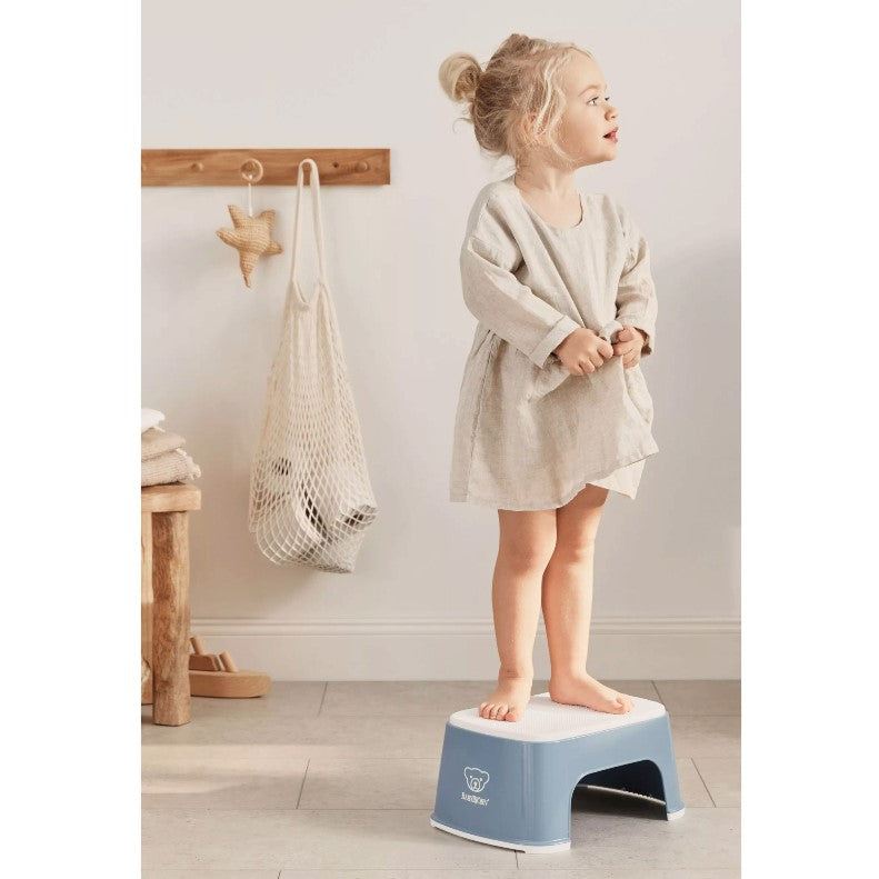 Girl standing on Babybjorn Blue Step Stool