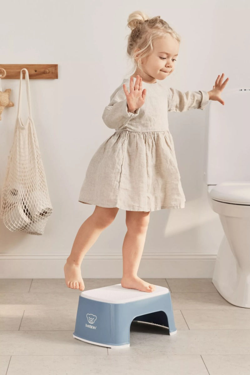 Girl balancing on Babybjorn Blue Step Stool