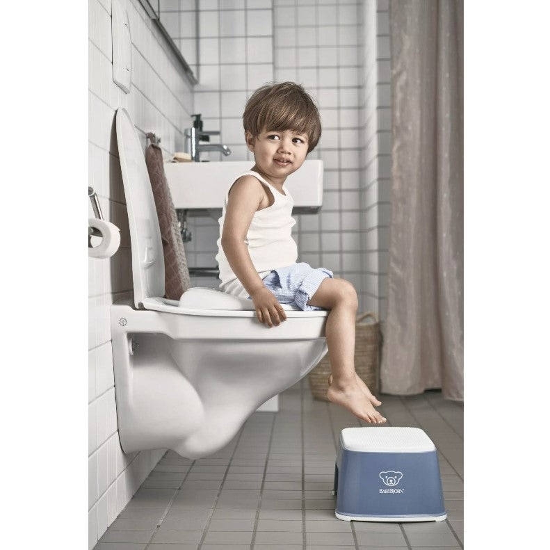 Boy in a bathroom using Babybjorn Blue Step Stool