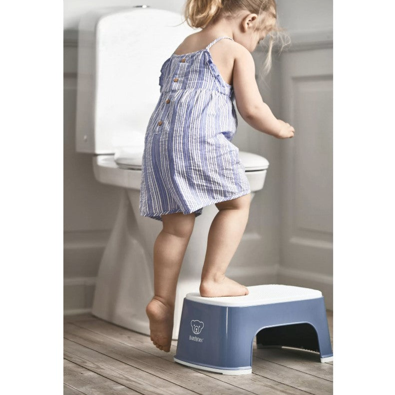 Baby girl using Babybjorn Blue Step Stool to sit on potty bowl