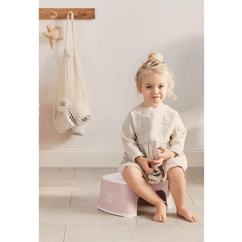 Baby girl sitting on a Babybjorn Powder Pink Step Stool