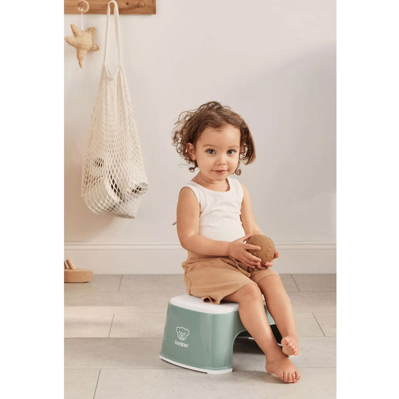 Baby boy sitting on a Babybjorn Deep green Step Stool