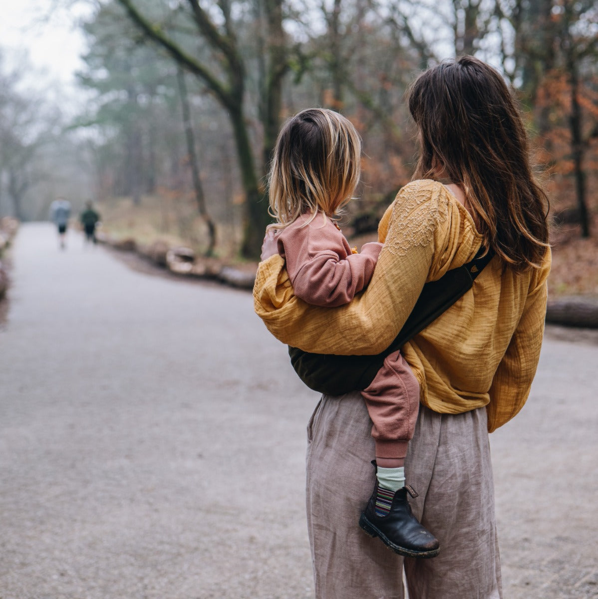 Mother carrying girl with Wildride Toddler Carrier in Army Green