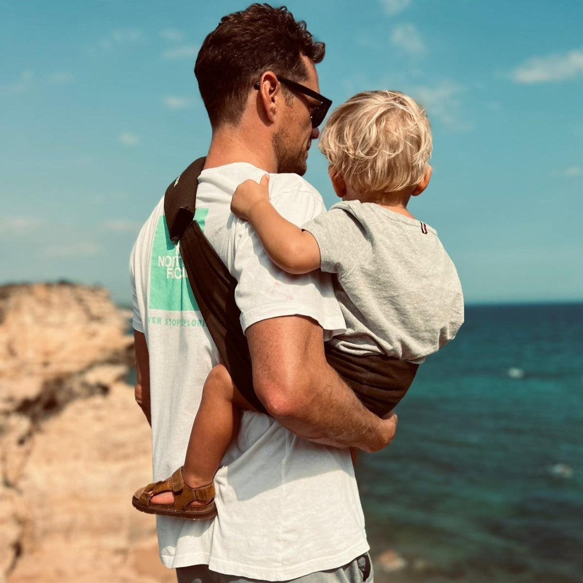 Father and Son at the beach using the Wildride Toddler Carrier in Coffee Colour