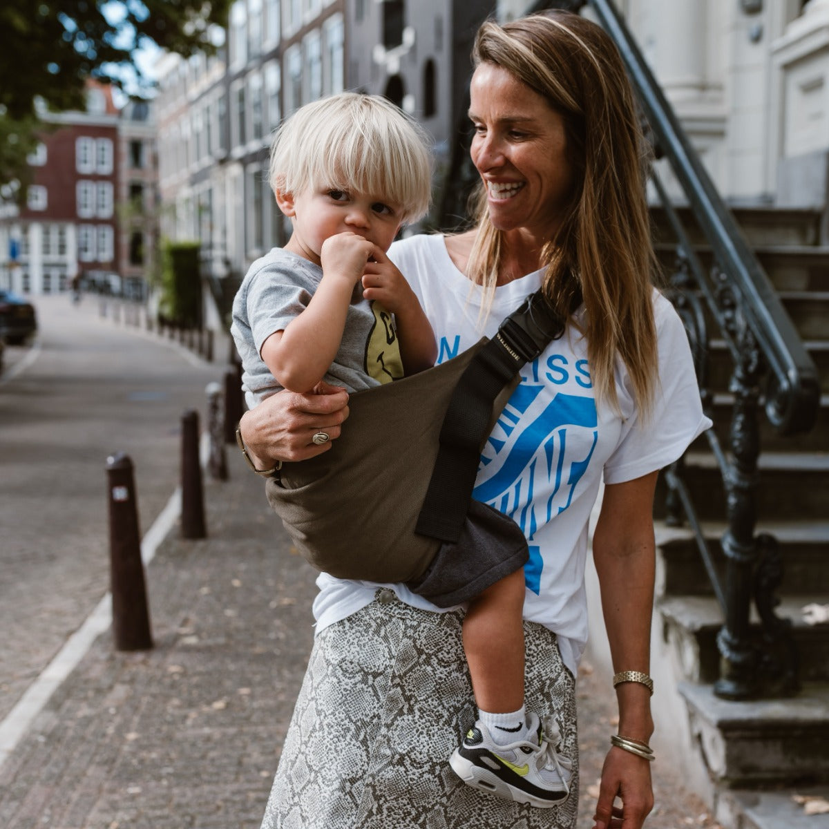 Mother and toddler in town with the Wildride Toddler Carrier in Coffee Colour