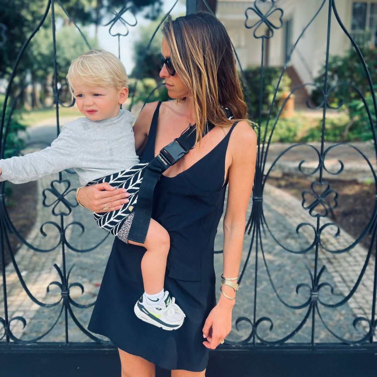 Mother holding toddler with Wildride Toddler Carrier with Feather Print 