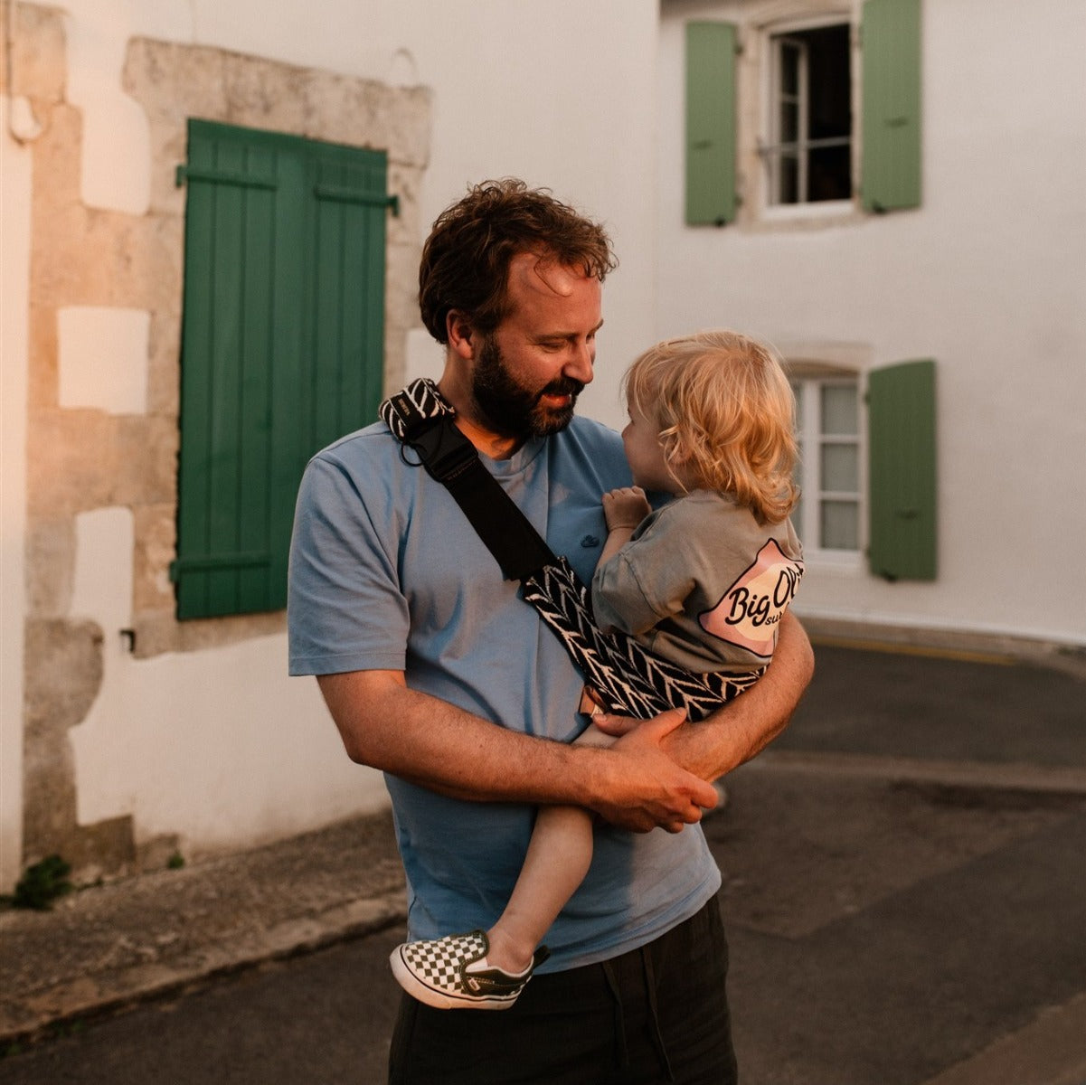 Father holding little boy with Wildride Toddler Carrier with Feather Print 