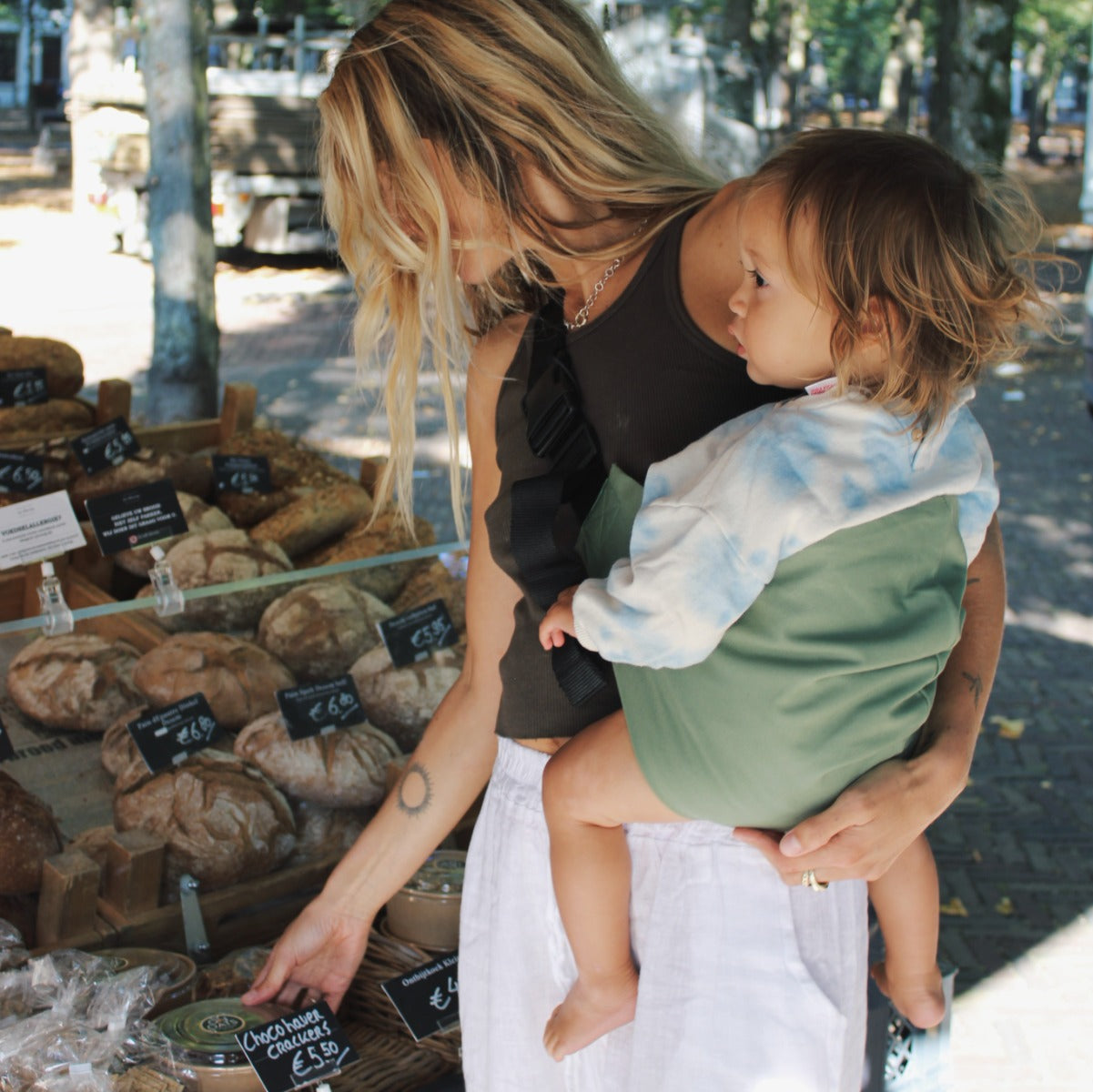 Lady holding toddler with Wildride Toddler Carrier in Fern colour