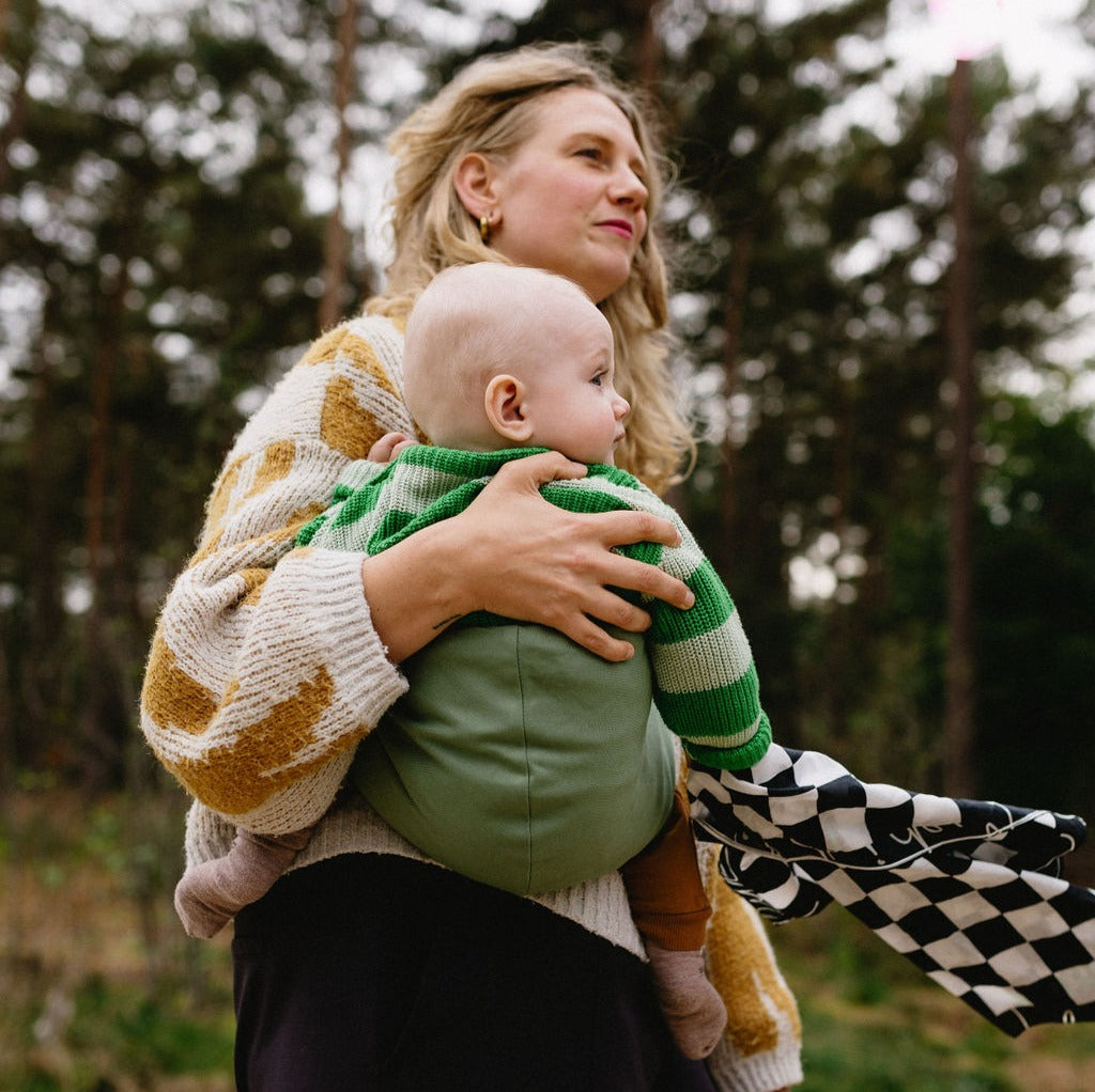 Close up of mother holding baby with Wildride Toddler Carrier in Fern colour