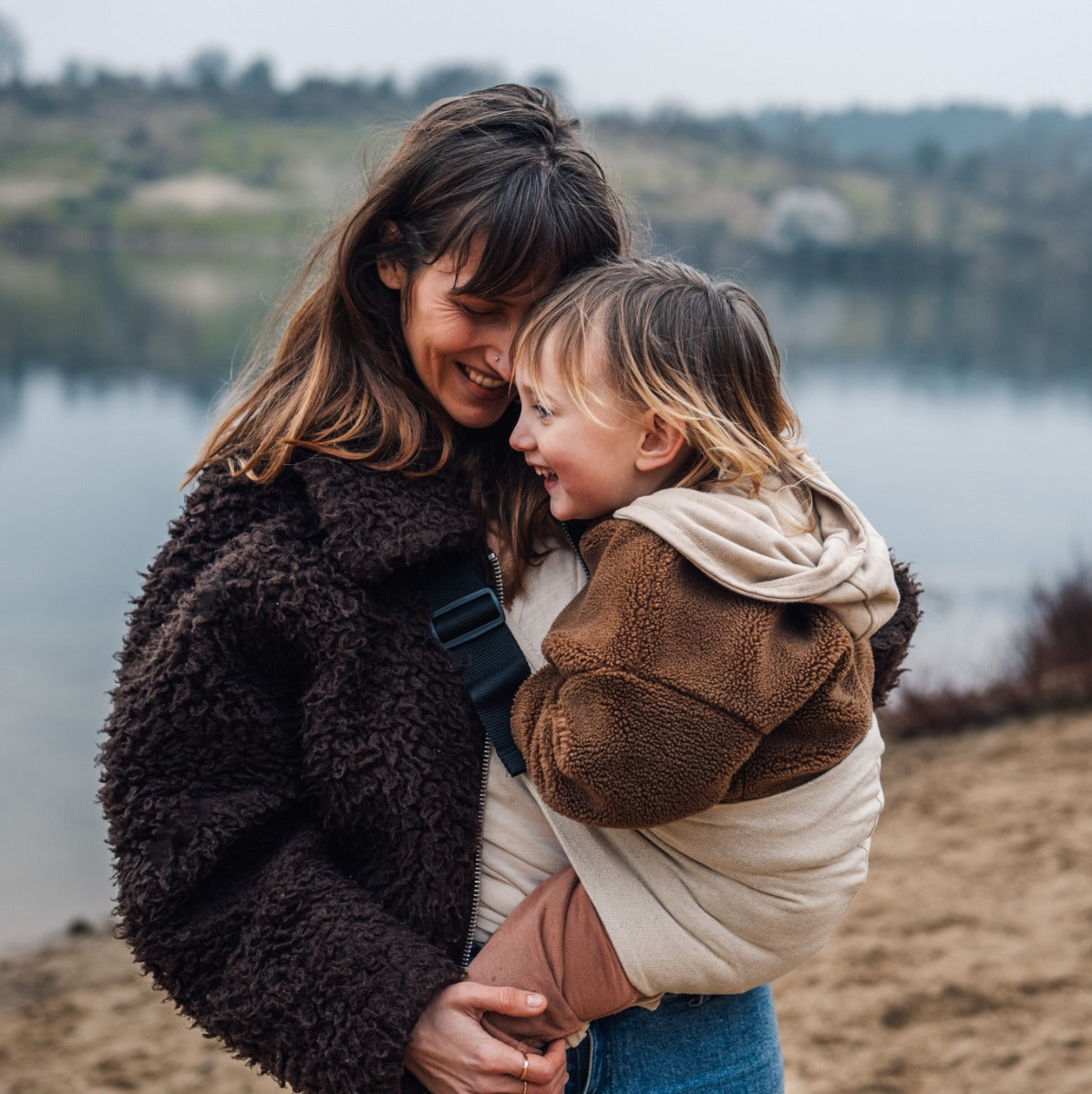Mother carrying Wildride Toddler Carrier in Sand near river