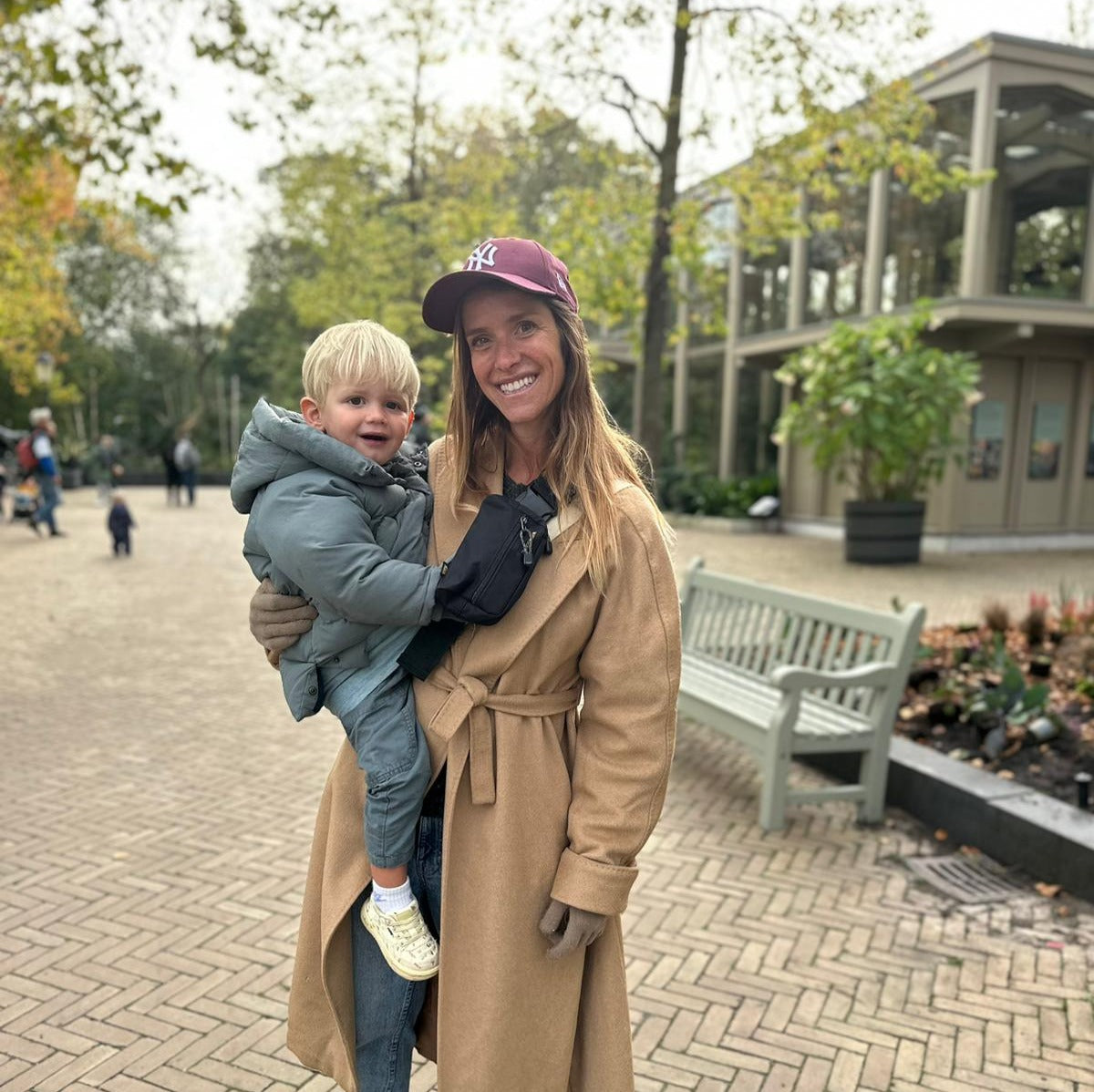 women wearing Wildride Slide On Bag in black while holding baby 