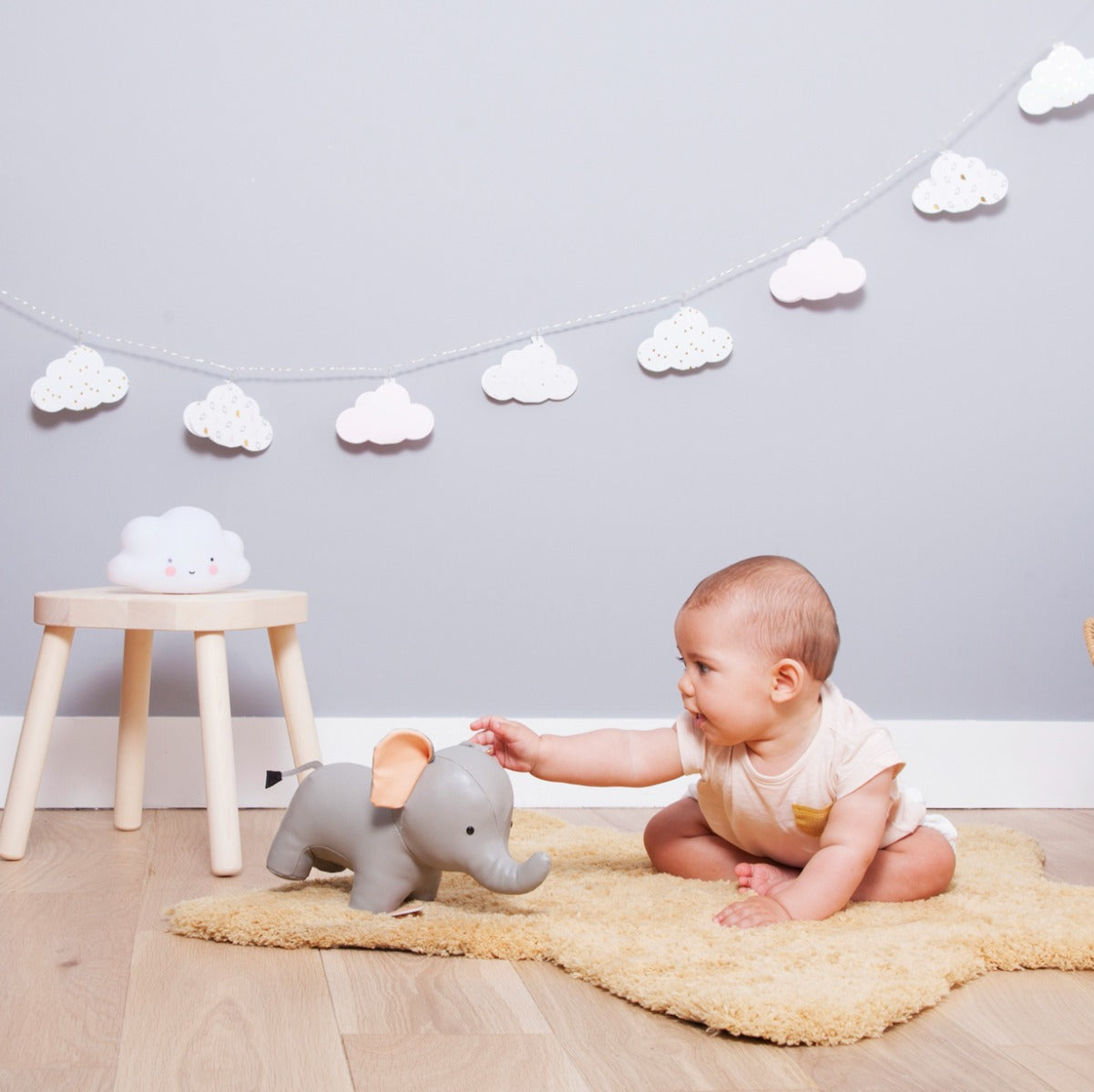 Baby playing with Musical elephant toy in grey from little big friends in nursery