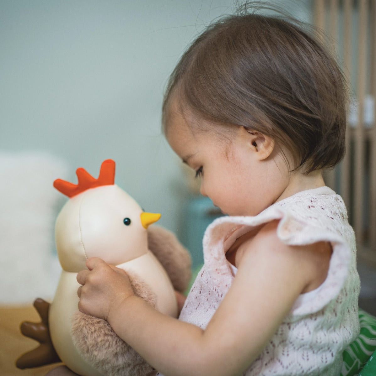 Girl playing with Musical Paulette the Hen toy in beige from little big friends