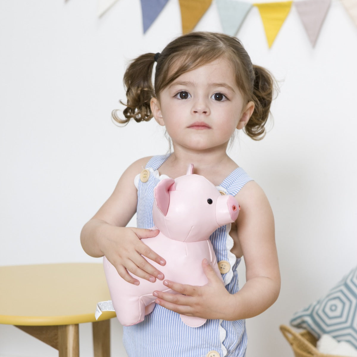 little girl holding Little big friends musical friend leon the pig 