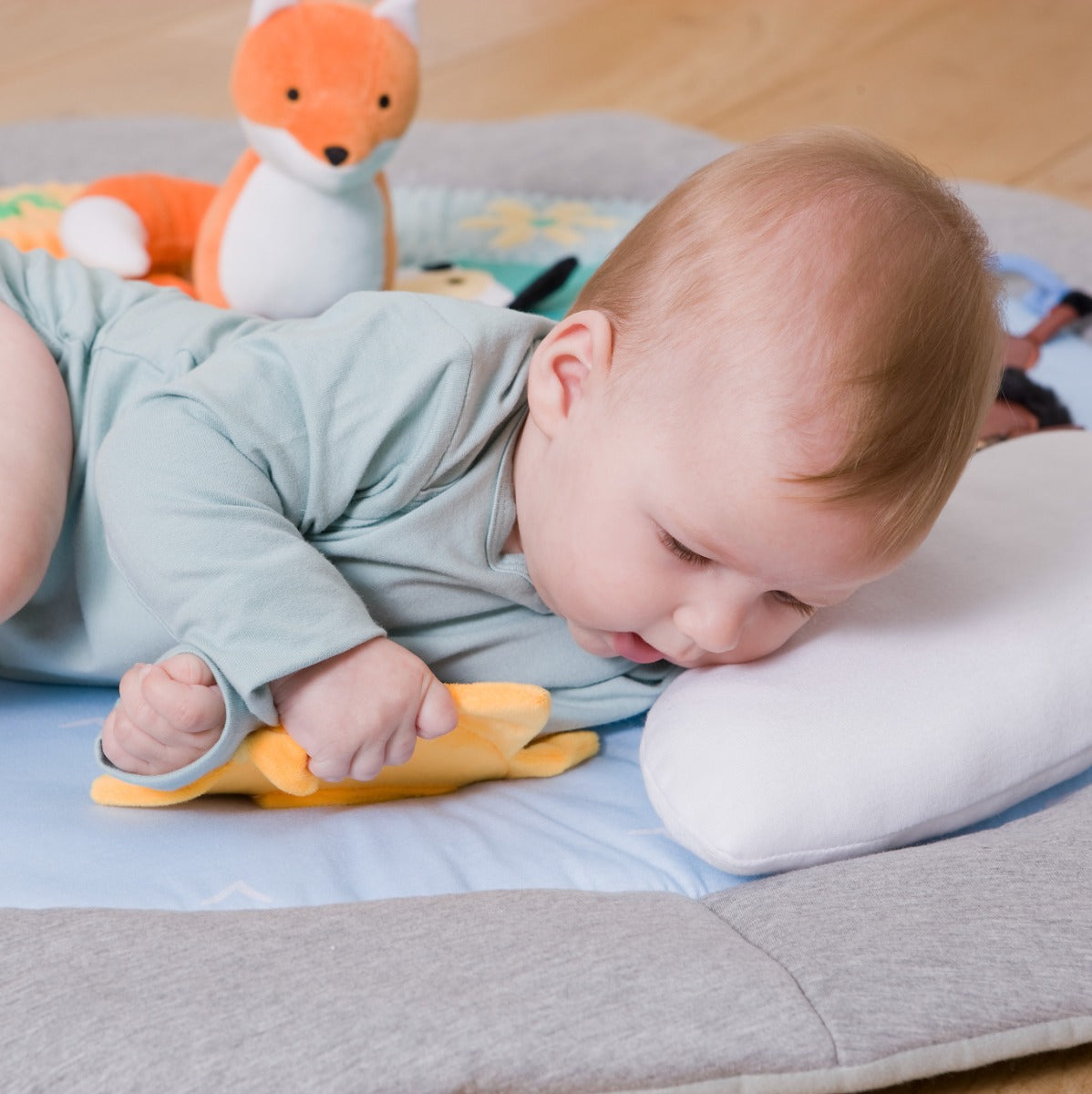 Baby lying on Little Big Friends Activity Playmat farm theme